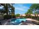 Sparkling pool with charming rock waterfall feature and clear blue skies in backyard at 35 E Secretariat Dr, Tempe, AZ 85284