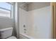 This bathroom features a built-in bathtub, white tile surround, safety bars, and a toilet at 3649 E Hazeltine Way, Chandler, AZ 85249