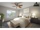 This bedroom boasts neutral tones, a ceiling fan, an area rug, and a comfortable upholstered bench at the foot of the bed at 3649 E Hazeltine Way, Chandler, AZ 85249
