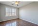 This bedroom features hardwood floors, a ceiling fan, and a large window to let in natural light at 3649 E Hazeltine Way, Chandler, AZ 85249
