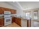 Kitchen with wooden cabinetry, granite countertops, and white appliances at 3649 E Hazeltine Way, Chandler, AZ 85249