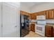 Kitchen features wooden cabinets, granite countertops, black refrigerator and white appliances at 3649 E Hazeltine Way, Chandler, AZ 85249