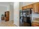 Kitchen area showcasing a black refrigerator and wooden cabinetry at 3649 E Hazeltine Way, Chandler, AZ 85249