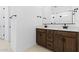 This bathroom features a double sink vanity with neutral wood cabinetry and bright white walls at 37727 W Padilla St, Maricopa, AZ 85138