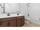 Bathroom featuring double sink vanity and an enclosed tub and shower combo with white subway tile surround at 37727 W Padilla St, Maricopa, AZ 85138