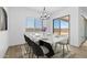 Bright dining room featuring a modern table, chandelier, and sliding glass doors at 37727 W Padilla St, Maricopa, AZ 85138