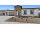 Charming single-story home featuring stone accents, a two-car garage, and desert landscaping at 37727 W Padilla St, Maricopa, AZ 85138