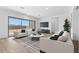 Cozy living room featuring modern furniture, sleek TV console, and bright windows at 37727 W Padilla St, Maricopa, AZ 85138