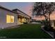 Twilight view of backyard, showing patio, lawn, and sunset with a nice tree at 402 E Windmere Dr, Phoenix, AZ 85048