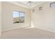 Bright bedroom with neutral carpet, ceiling fan and mountain views from a large window at 402 E Windmere Dr, Phoenix, AZ 85048