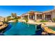 Backyard features a gorgeous pool and spa, framed by rock features and desert views at 402 E Windmere Dr, Phoenix, AZ 85048
