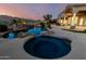 A luxurious backyard boasts a custom pool with integrated spa, rock waterfall, and lush desert landscaping at 402 E Windmere Dr, Phoenix, AZ 85048