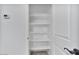 Linen closet with white shelving and a textured door with black hardware at 4125 W Gary Way, Laveen, AZ 85339