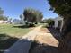 Manicured lawns and mature trees frame sidewalk path, offering shaded walkways and tranquil common area at 4652 W Desert Crest Dr, Glendale, AZ 85301