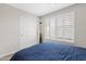 Well-lit bedroom boasts a queen bed, a large window with shutters, and a spacious closet at 4976 E Thunderbird Dr, Chandler, AZ 85249