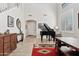 Entryway with a grand piano, dining table, and natural light from shuttered windows at 4976 E Thunderbird Dr, Chandler, AZ 85249