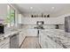 Bright kitchen with granite countertops, stainless steel appliances, and light wood-look flooring at 4976 E Thunderbird Dr, Chandler, AZ 85249