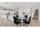 Bright, modern kitchen featuring white cabinets, stainless appliances, and a glass-top dining table at 4976 E Thunderbird Dr, Chandler, AZ 85249