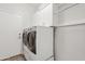 Functional laundry room includes modern washer and dryer with storage cabinets above at 4976 E Thunderbird Dr, Chandler, AZ 85249