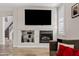 Living room with a fireplace and wall-mounted TV in a neutral color scheme at 4976 E Thunderbird Dr, Chandler, AZ 85249