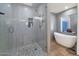 This bathroom features an updated walk-in shower with a pebble floor and a modern soaking tub at 524 W Sunset Cir, Mesa, AZ 85201