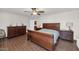 This bedroom includes a ceiling fan, wood floors, and coordinated dark wood furniture at 524 W Sunset Cir, Mesa, AZ 85201