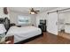 This bedroom boasts wood floors, a ceiling fan, and a connecting bathroom behind a sliding door at 524 W Sunset Cir, Mesa, AZ 85201