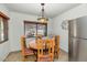 Cozy dining area features a wooden table, decorative lighting, and a stainless steel refrigerator at 524 W Sunset Cir, Mesa, AZ 85201