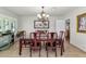 Formal dining room featuring a dark wood table set for six under an ornate chandelier and complementary wall art at 524 W Sunset Cir, Mesa, AZ 85201