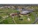 Aerial shot of a golf course and clubhouse showing greens, practice area, and tennis courts at 524 W Sunset Cir, Mesa, AZ 85201