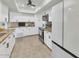 Modern kitchen featuring white cabinets, granite countertops, tile flooring, and stainless steel appliances at 524 W Sunset Cir, Mesa, AZ 85201