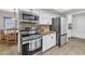 Well-lit kitchen with stainless steel appliances, white cabinetry, and eat-in dining, blending style with functionality at 524 W Sunset Cir, Mesa, AZ 85201
