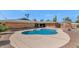 Inviting in-ground pool with a circular lounge area surrounded by lush landscaping and a brick home at 524 W Sunset Cir, Mesa, AZ 85201