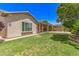 Well-maintained backyard featuring lush green grass, a covered patio, and mature landscaping at 5541 W Desperado Way, Phoenix, AZ 85083