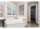 Bathroom with a large soaking tub, tiled floors, and natural light from windows at 5541 W Desperado Way, Phoenix, AZ 85083