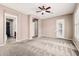 Carpeted living room with a ceiling fan, neutral paint, and multiple doorways at 5541 W Desperado Way, Phoenix, AZ 85083