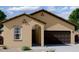 Charming single-story home with a neutral-toned exterior, arched entryway, and a two-car garage at 6029 E Artemis Dr, Florence, AZ 85132