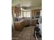 Charming kitchen featuring wood cabinets, a stainless steel dishwasher, and lots of natural light from the large window at 6036 W Mescal St, Glendale, AZ 85304