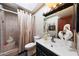 Bathroom with a tiled shower, black vanity, and decorative elements at 7368 E Pleasant Run, Scottsdale, AZ 85258