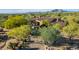 Expansive estate showcasing lush landscaping and a grand entrance with a circular driveway at 7552 E Whisper Rock Trl, Scottsdale, AZ 85266