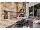 Cozy living room featuring a stone fireplace, a large window, and comfortable seating at 7552 E Whisper Rock Trl, Scottsdale, AZ 85266
