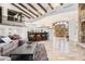 Open-concept living room with high ceilings, wooden beams, bar area and stone floors at 7552 E Whisper Rock Trl, Scottsdale, AZ 85266