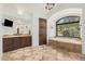 Main bathroom with a soaking tub, a large arched window, and a custom vanity at 7552 E Whisper Rock Trl, Scottsdale, AZ 85266