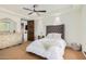 Bright bedroom featuring ceiling fan, tufted headboard, and ensuite bathroom at 7552 E Whisper Rock Trl, Scottsdale, AZ 85266