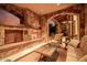 Covered patio with stone fireplace, comfortable seating, and views of the outdoor landscape at 7552 E Whisper Rock Trl, Scottsdale, AZ 85266