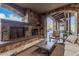 Covered patio with stone fireplace, comfortable seating, and views of the outdoor landscape at 7552 E Whisper Rock Trl, Scottsdale, AZ 85266