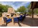 Comfortable outdoor patio with a stone fireplace and plenty of seating is perfect for relaxing and entertaining at 7552 E Whisper Rock Trl, Scottsdale, AZ 85266