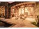 Charming backyard patio with stone architecture, lounge chairs, and outdoor lighting at 7552 E Whisper Rock Trl, Scottsdale, AZ 85266