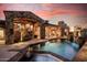 Exterior pool and patio with stone architecture and sunset view at 7552 E Whisper Rock Trl, Scottsdale, AZ 85266