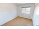 This bedroom has neutral carpet, white walls, and a window overlooking the neighborhood at 8541 W Pershing Ave, Peoria, AZ 85381